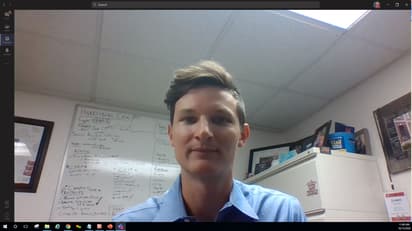 A man looks at the camera in a virtual meeting.